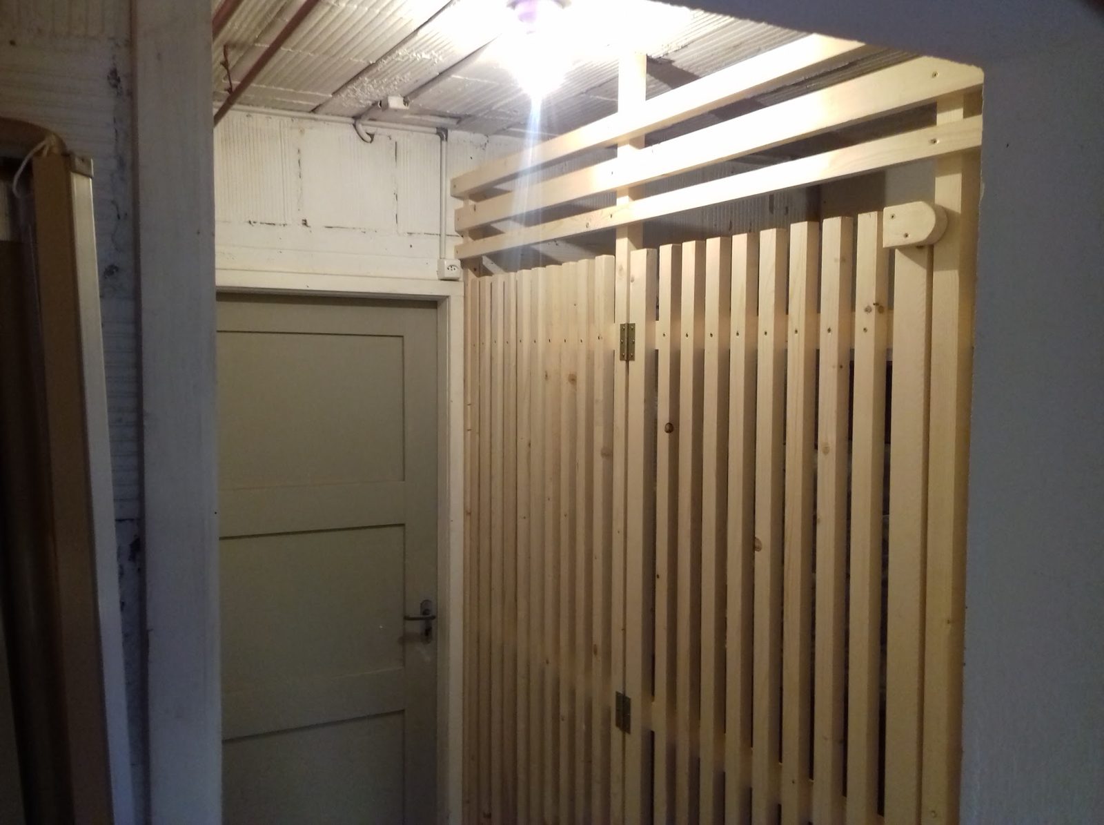 Holzlattenwand im Innenausbau neben einer Tür